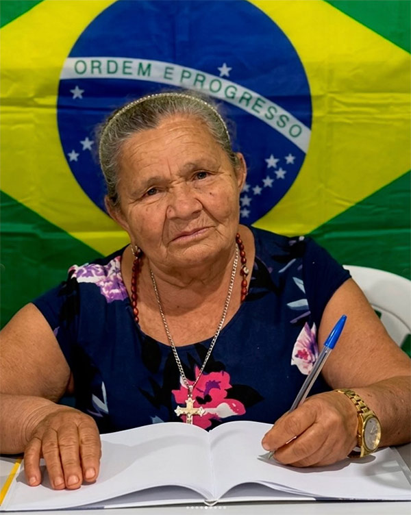 Aluna EJA escrevendo no caderno